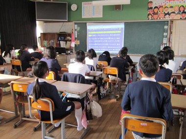 Pupils reading a DAISY textbook projected on a blackboard.