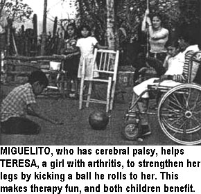 MIGUELITO, who has cerebral palsy, helps TERESA, a girl with arthritis, to strengthen her legs by kicking a ball he rolls to her. This makes therapy fun, and both children benefit.