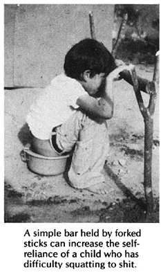 A simple bar held by forked sticks can increase the self-reliance of a child who has difficulty squatting to shit