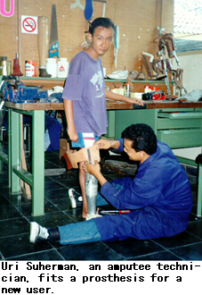 Uri Suherman, an amputee technician, fits a prosthesis for a new user.