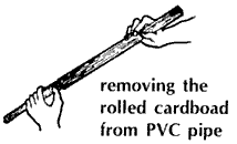 Removing the rolled cardboard from PVC pipe.