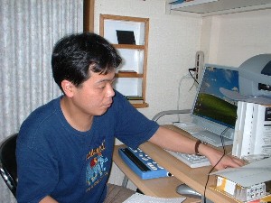 photo of young Japanese deaf-blind man using a computer
