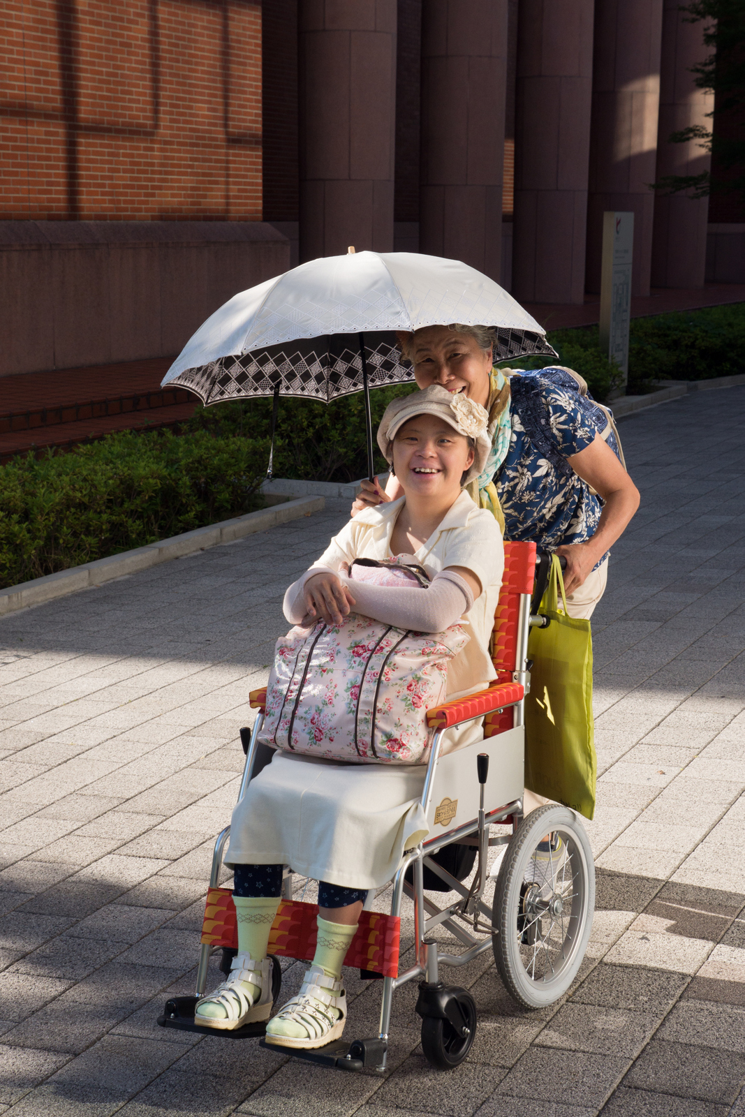 日傘を差し車椅子の真理さんとお母さん