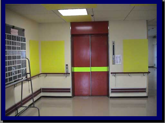 エレベーターの扉の写真、扉に黄色い横線と両隣の壁が黄色い布のようなものを貼り付けている