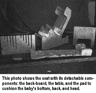 This photo shows the seat with its detachable components: the back-board, the table, and the pad to cushion the baby's bottom, back, and head.