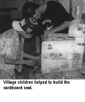 Village children helped to build the cardboard seat.