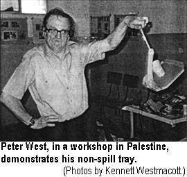 Peter West, in a workshop in Palestine, demonstrates his non-spill tray.