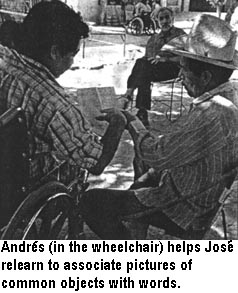 Andres (in the wheelchair) helps Joses relearn to associate pictures of common objects with words.
