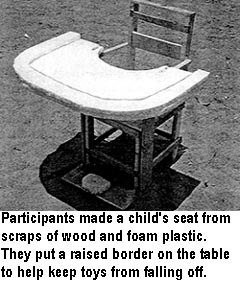Participants made a child's seat from scraps of wood and foam plastic. They put a raised border on the table to help keep toys from falling off.