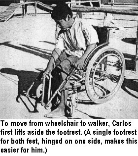 To move from wheelchair to walker, Carlos first lifts aside the footrest. (A single footrest for both feet, hinged on one side, makes this easier for him.)
