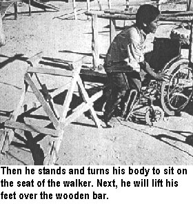 Then he stands and turns his body to sit on the seat of the walker. Next, he will lift his feet over the wooden bar.