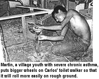 Martín, a village youth with severe chronic asthma, puts bigger wheels on Carlos' toilet walker so that it will roll more easily on rough ground.