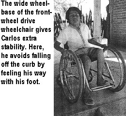 The wide wheel-base of the front-wheel drive wheelchair gives Carlos extra stability. Here, he avoids falling off the curb by feeling his way with his foot.
