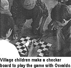 Village children make a checker board to play the game with Osvaldo.