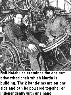 Ralf Hotchkiss examines the one arm drive wheelchair which Martín is building. The 2 hand-rims are on one side and can be powered together or independently with one hand.