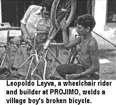 Leopoldo Leyva, a wheelchair rider and builder at PROJIMO, welds a village boy's broken bicycle.