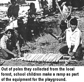 Out of poles they collected from the local forest, school children make a ramp as part of the equipment for the playground.