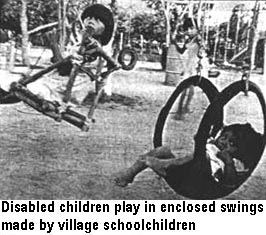 Disabled children play in enclosed swings made by village schoolchildren.