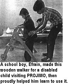A school boy, Efrain, made this wooden walker for a disabled child visiting PROJIMO, then proudly helped him learn to use it.