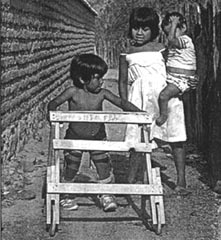 Standing behind Jesica (with the walker), a school-girl called Gordi holds little Toni.