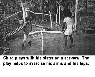 Chiro plays with his sister on a see-saw. The play helps to exercise his arms and his legs.