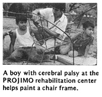 A boy with cerebral palsy at the PROJIMO rehabilitation center helps paint a chair frame.