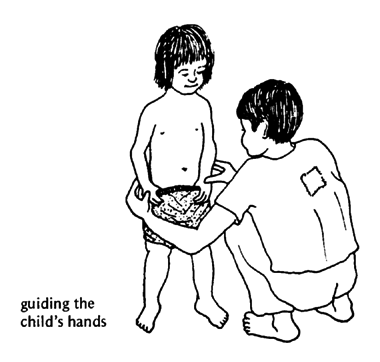 Guide the child's movement with your hands.