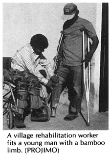 A village rehabilitation worker fits a young man with a bamboo lib. (PROJIMO)