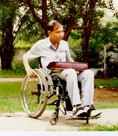 A man riding his wheelchair is on his way to the office.