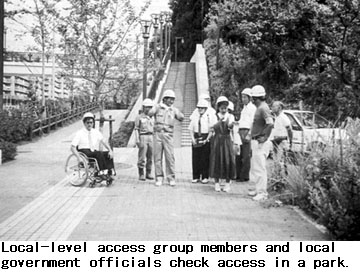 Local-level access group members and local government officials check access in a park.