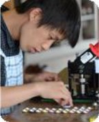  A staff of a welfare workshop is making the Can-Badges.