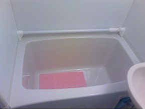 The bath tub attached a bar utilized as a hand-rail for a first-aid