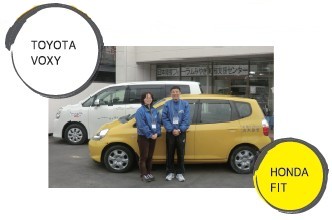 supporters of Miyagi Support Center standing in front of two cars donated