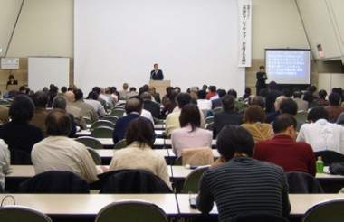 鴨下氏の話を熱心に聞く大勢の聴講者の写真