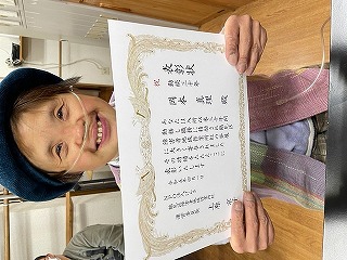 虹作業所30年表彰状を見せているマリさん