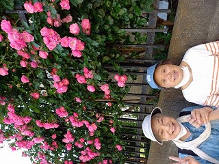 バラの花をバックに磯村さんとマリさんの写真