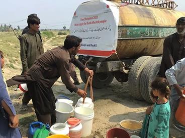 Photo of a water tanker and people 