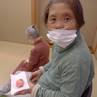 花びら餅の梅のお菓子を持つマリさん