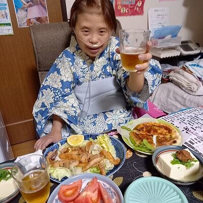 マリさんがコップでビールを持っている写真