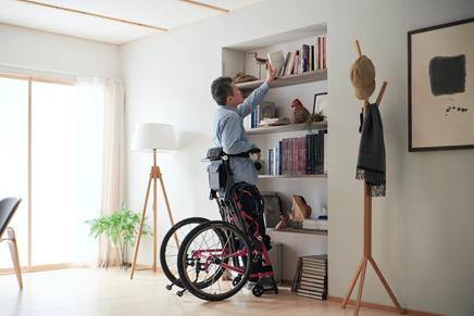 Photo of a bookshelf and a person in a wheelchair