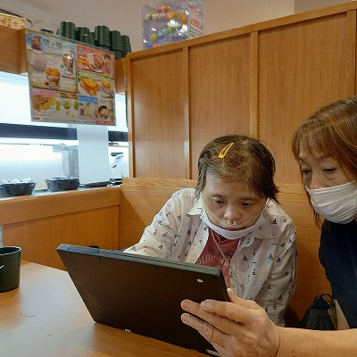 お寿司屋さんで注文するマリさんとヘルパーさん