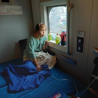 電車の個室で窓際にいるマリさん