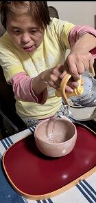 ガラスポットでお茶を注いでいるマリさん