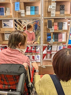 ドコモショップでスマホを選んでいるマリさん