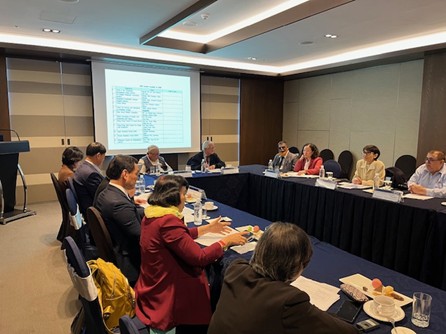 APDF総会の様子。スクリーンに新役員名簿が投影され、各国の代表がテーブルを囲んで会議を行っている